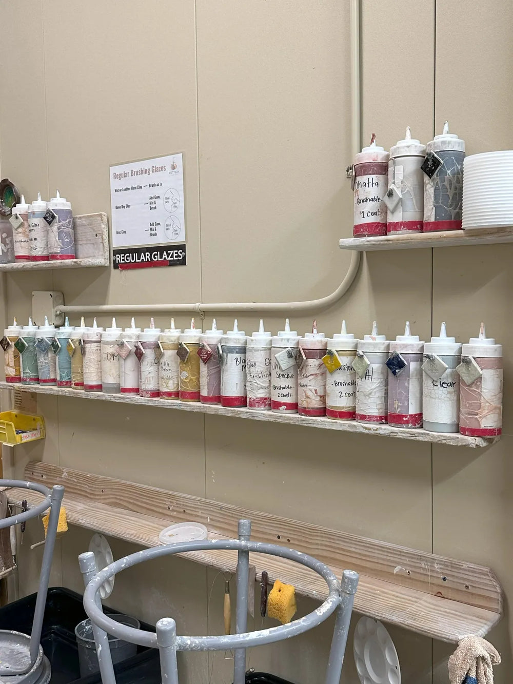 Row of hand-labeled glaze bottles